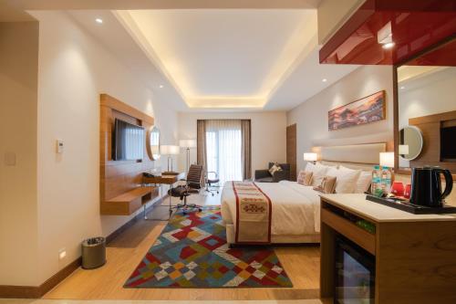 a large hotel room with a bed and a desk at Ramada Encore by Wyndham Kathmandu Thamel in Kathmandu
