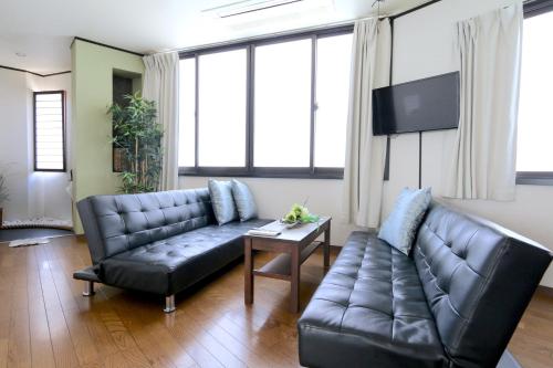 a living room with a couch and a table at Liz3 Guest House Liz Nakazakicho in Osaka
