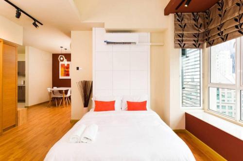 a bedroom with a large white bed with red pillows at Parkview Residence Family Studio in Kuala Lumpur