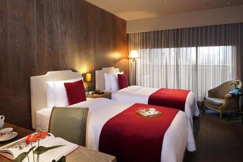 a hotel room with two beds and a table at Palais de Chine Hotel in Taipei