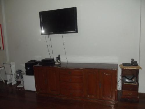 a flat screen tv on top of a wooden dresser at Apartamento Copacabana 243 in Rio de Janeiro