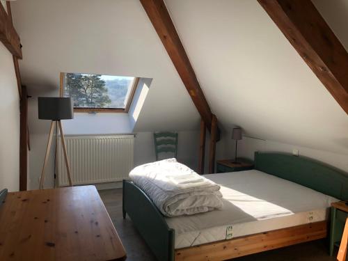 Schlafzimmer mit einem Bett, einem Tisch und einem Fenster in der Unterkunft Les Gîtes du Paradis in Murol