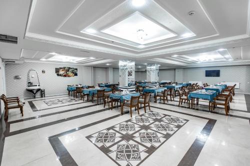 a large banquet hall with blue tables and chairs at OydinPlaza Hotel in Namangan