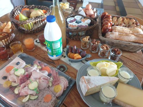 Una mesa cubierta con platos de comida y cestas de comida. en Écrin de Nature en bord de rivière, en Cenans