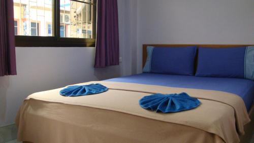 Una cama con dos almohadas azules encima. en Candy House, en Patong Beach