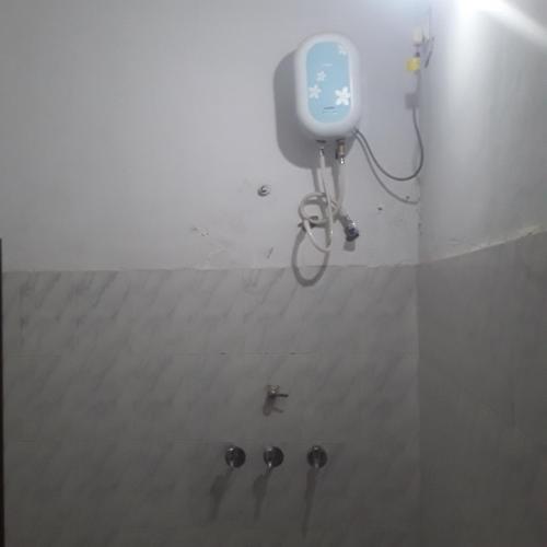 a shower in a room with a bike on the wall at shri bake bihari guest house in Gwalior