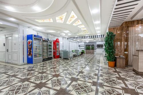 a lobby with a coca cola machine on a tile floor at OydinPlaza Hotel in Namangan