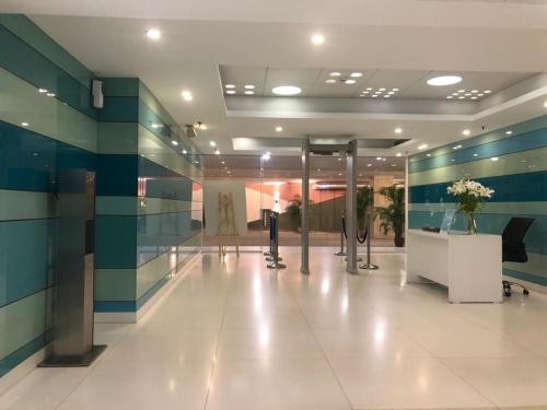 a lobby with blue and green striped walls and a hallway at Cocoon Luxury Business Hotel in Dhanbād