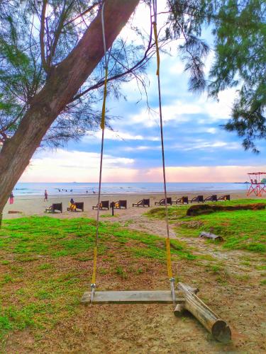 a swing hanging from a tree on the beach at Le'Coco Homestay in Tiara Desaru Residence in Desaru