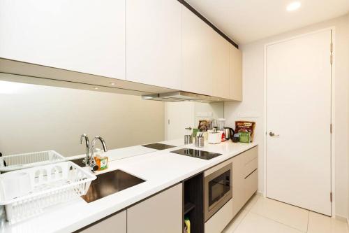 a white kitchen with a sink and a stove at Urban hive in Bukit Bintang I Robertson Residence in Kuala Lumpur