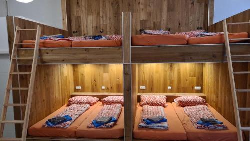 three bunk beds in a room with orange beds at Flensburg City - 24h in Flensburg