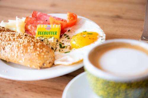 a plate with an egg and a sandwich and a cup of coffee at Pension Sandhof in Knittelfeld