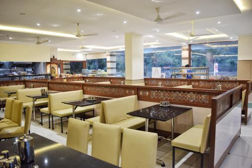 um restaurante com mesas e cadeiras e um bar em Bhramari Nest em Subrahmanya
