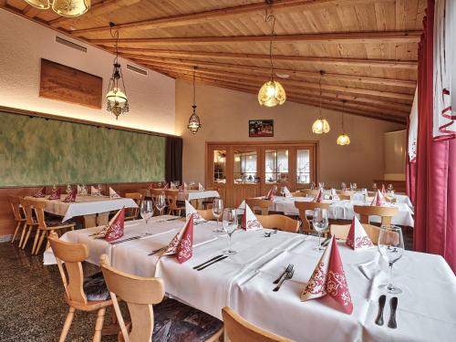 a restaurant with white tables and chairs and a large screen at TIPTOP Hotel am Hochrhein in Bad Säckingen