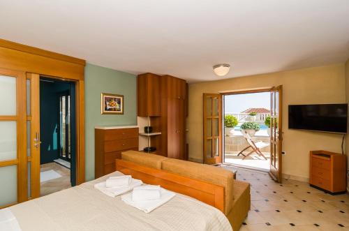 a bedroom with a large bed and a television at Studio Antica, apartment with a private swimming pool in Močići