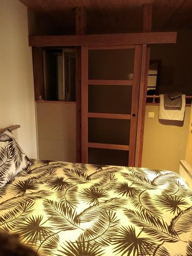 a bedroom with a bed with a black and white comforter at Le Relais du Moulin in Gedinne