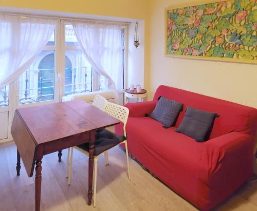 a living room with a red couch and a table at Porta Venezia & Giardini Montanelli Cozy Flat in Milan