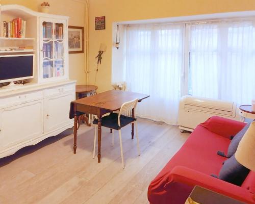 a living room with a table and a red couch at Porta Venezia & Giardini Montanelli Cozy Flat in Milan