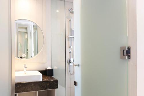 a bathroom with a sink and a mirror at Swiss-Belinn Cikarang in Cikarang
