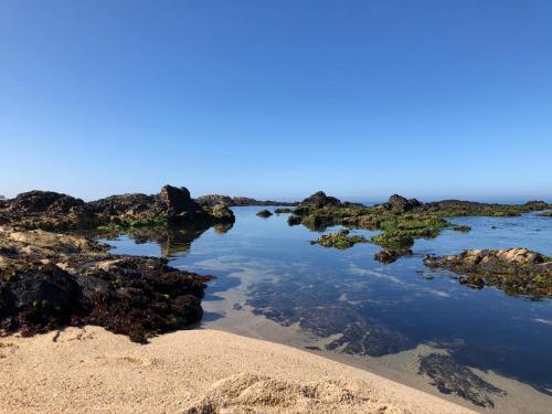 a beach with rocks and the ocean in the background at Casa na Praia in Póvoa de Varzim