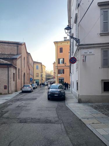 a street with cars parked on the side of the road at Empire - Affittacamere in Modena
