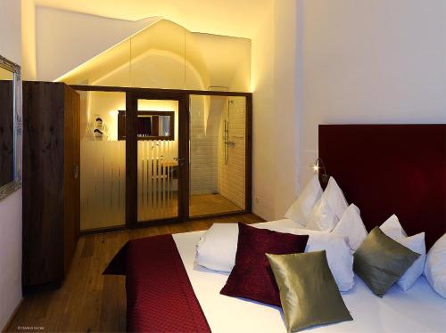 a bedroom with a bed with white sheets and pillows at Hotel Landhaus Moserhof in Gumpoldskirchen