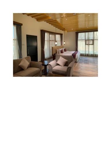 a living room with couches and tables and windows at Arabian Nights Resort & Spa in Shāhiq