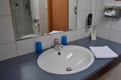 a bathroom counter with a sink and a mirror at Hotel Sammeth Bräu in Weidenbach