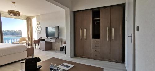 a bedroom with a bed and a desk and a television at Le Relais Du Lac in Hossegor