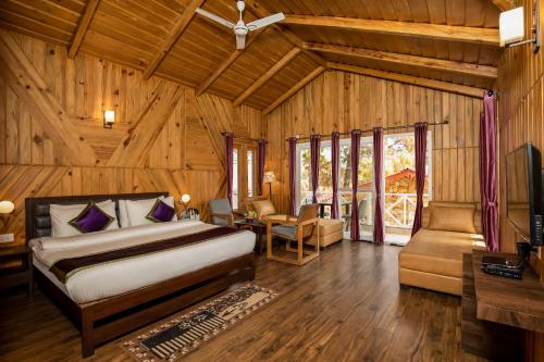 a bedroom with a bed and a couch and a table at The Nature's Green Resort, Bhimtal, Nainital in Nainital