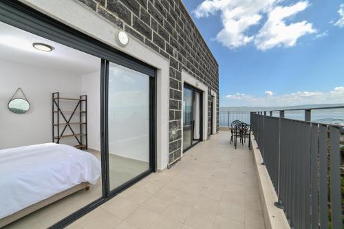1 dormitorio con 1 cama en un balcón con vistas al océano en Europa Residence en Tiberias