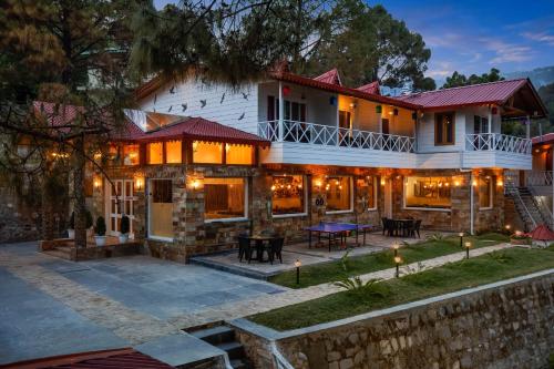 a house with a patio in front of it at The Nature's Green Resort, Bhimtal, Nainital in Nainital