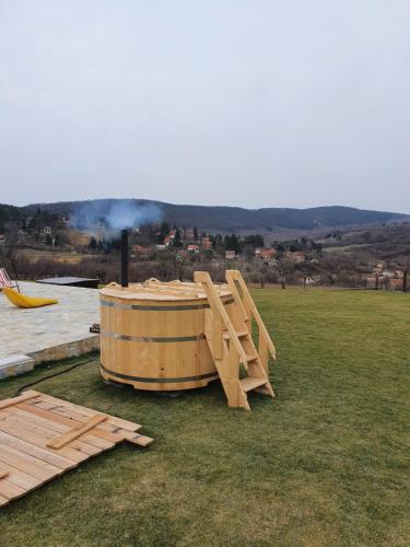 a large wooden barrel sitting on top of a field at Imperator Kvintil apartmani & SPA in Ležimir