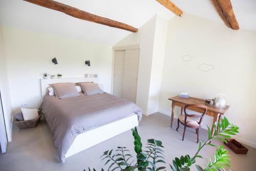 - une chambre avec un lit et une table en bois dans l'établissement Le Relais de la Godasse, à Reyrieux