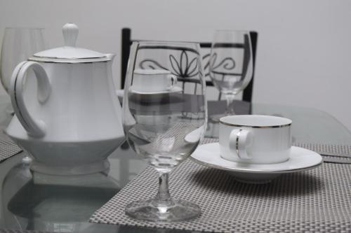 a table with two wine glasses and a cup on it at Villa 307 3 room apartment in Matara