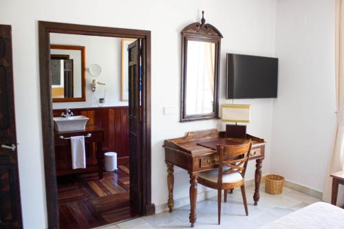 bagno con scrivania, lavandino e specchio di Hotel Hacienda Montenmedio a Vejer de la Frontera