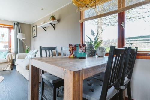 een eetkamer met een houten tafel en stoelen bij Chalet 41 - Haayse Bos Ouddorp - Not for companies - In the middle of nature near the beach in Ouddorp