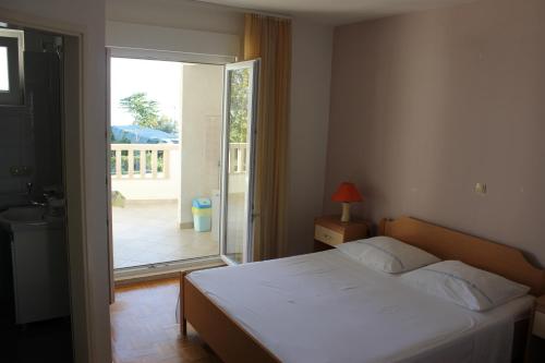 1 dormitorio con 1 cama y puerta a un balcón en Omiš Duće sandy beach apartments Mare, en Omiš