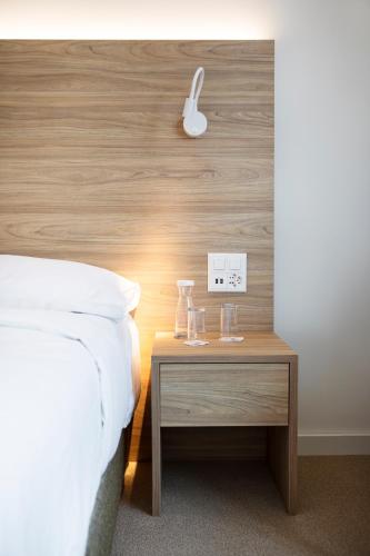 a bedroom with a bed and a table with glasses on it at Continental Hotel Lausanne in Lausanne