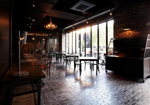 um restaurante com piano, mesas e cadeiras em Lee Design Hotel em Yongin
