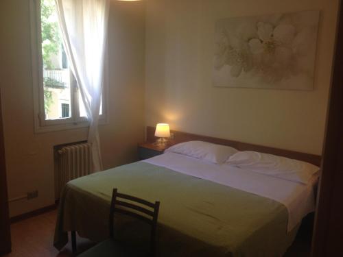 1 dormitorio con 1 cama con manta verde y ventana en Hotel Terme Belvedere en Abano Terme