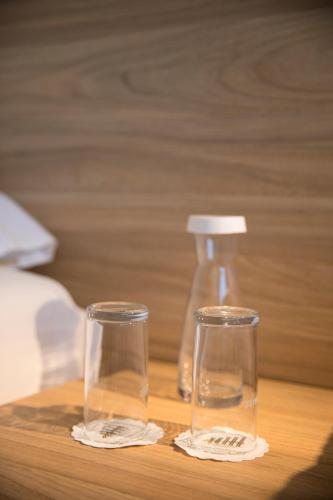 two glasses and a bottle on a wooden table at Continental Hotel Lausanne in Lausanne