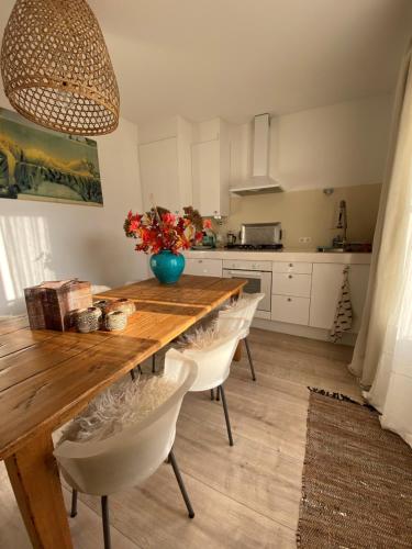 a kitchen with a wooden table and white cabinets at Casa Blanca Old City - Alkmaar in Alkmaar