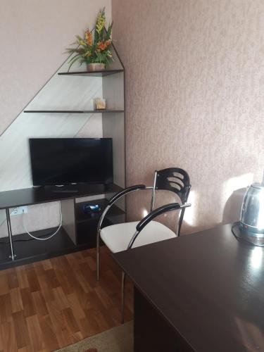 a room with two chairs and a desk with a television at Dniprovski Zori in Kremenchuk