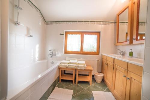 y baño con lavabo, bañera y mesa. en Landhotel Spreitzhofer en Sankt Kathrein am Offenegg