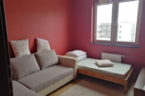 a living room with a couch and a window at Komfortowy Apartament dla turystów i pracowników in Gdańsk