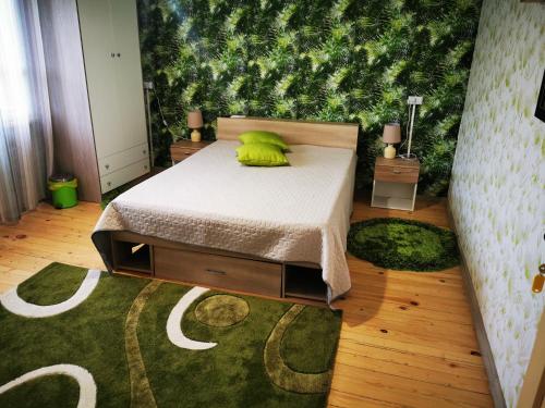 um quarto com uma cama e uma parede verde em Къща за гости и приятели Селановска среща em Selanovtsi