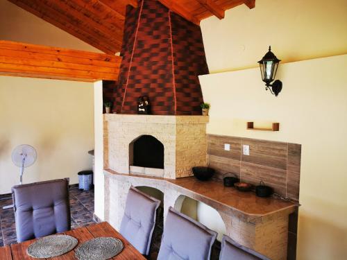 uma sala de jantar com lareira, mesa e cadeiras em Къща за гости и приятели Селановска среща em Selanovtsi