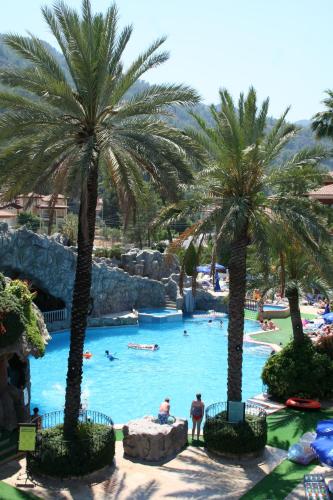 a pool with palm trees in a resort at Grand Aquarium in Marmaris