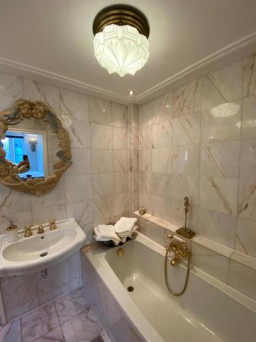 a bathroom with a sink and a tub and a mirror at Casa Blanca Old City - Alkmaar in Alkmaar